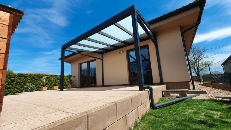 Modern, antracit színű alumínium pergola üvegezett tetővel egy családi ház teraszán