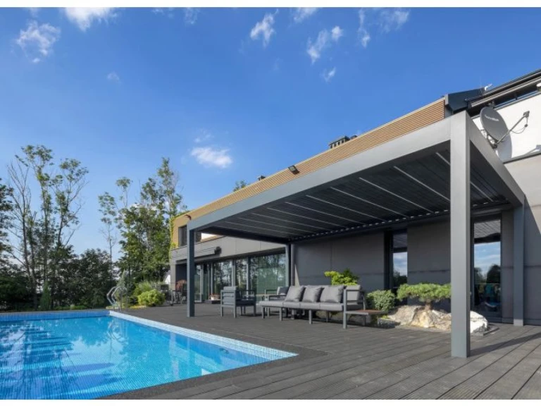 A modern, szürke SUNBEAM 1400 bioklimatikus pergola a medence melletti teraszon, kültéri ülőgarnitúrával