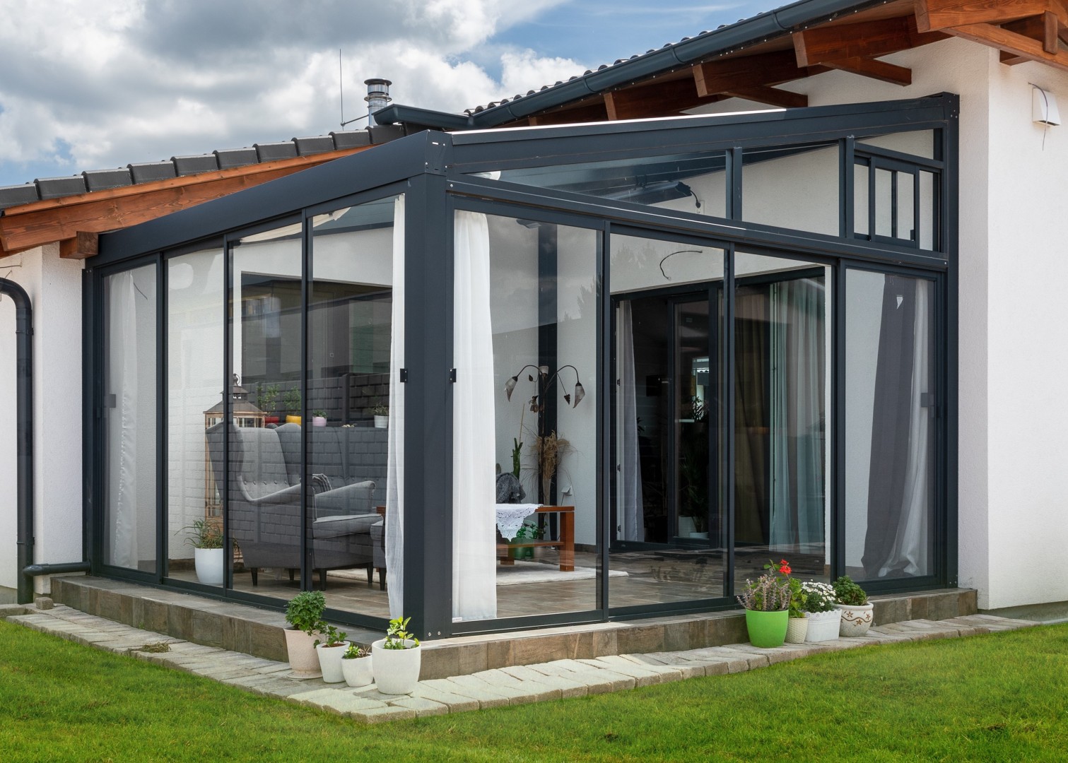 A házhoz csatlakozó, modern, üvegezett alumínium pergola, elegáns belső bútorokkal.