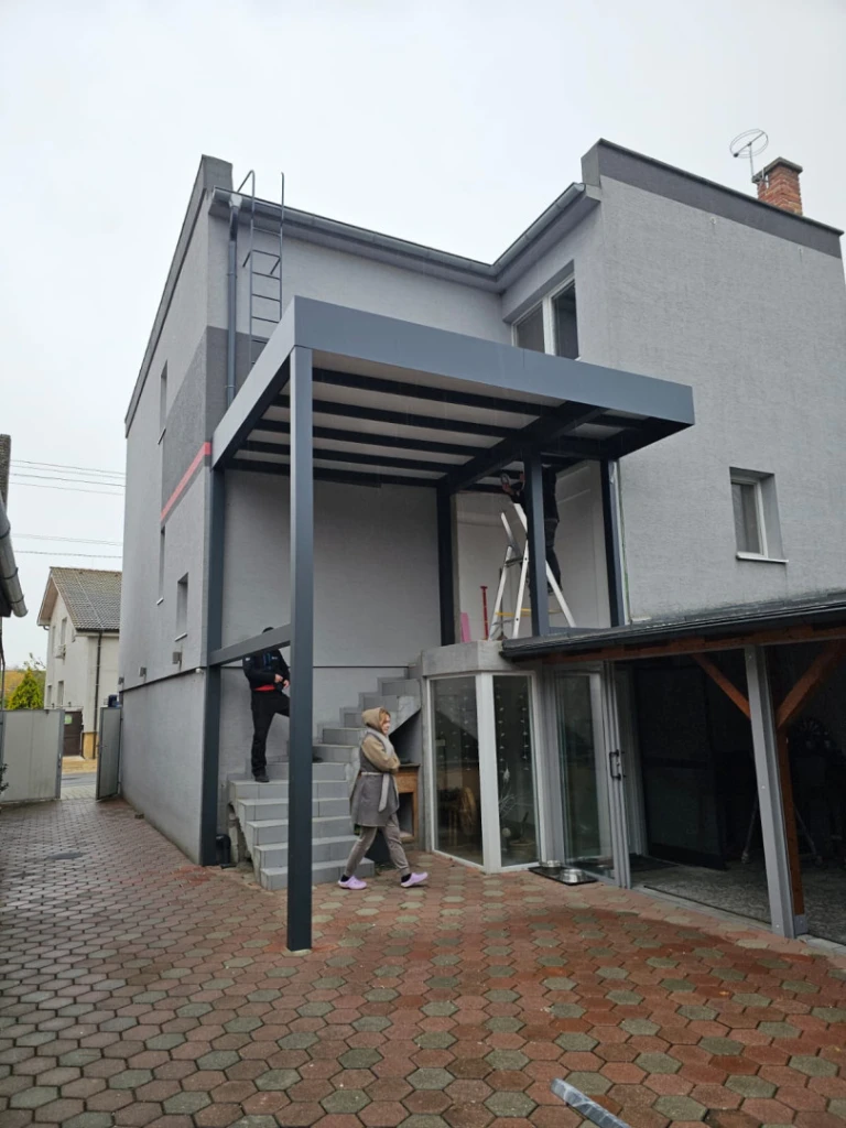 Egy családi ház teraszára felszerelt modern, szürke alumínium pergola