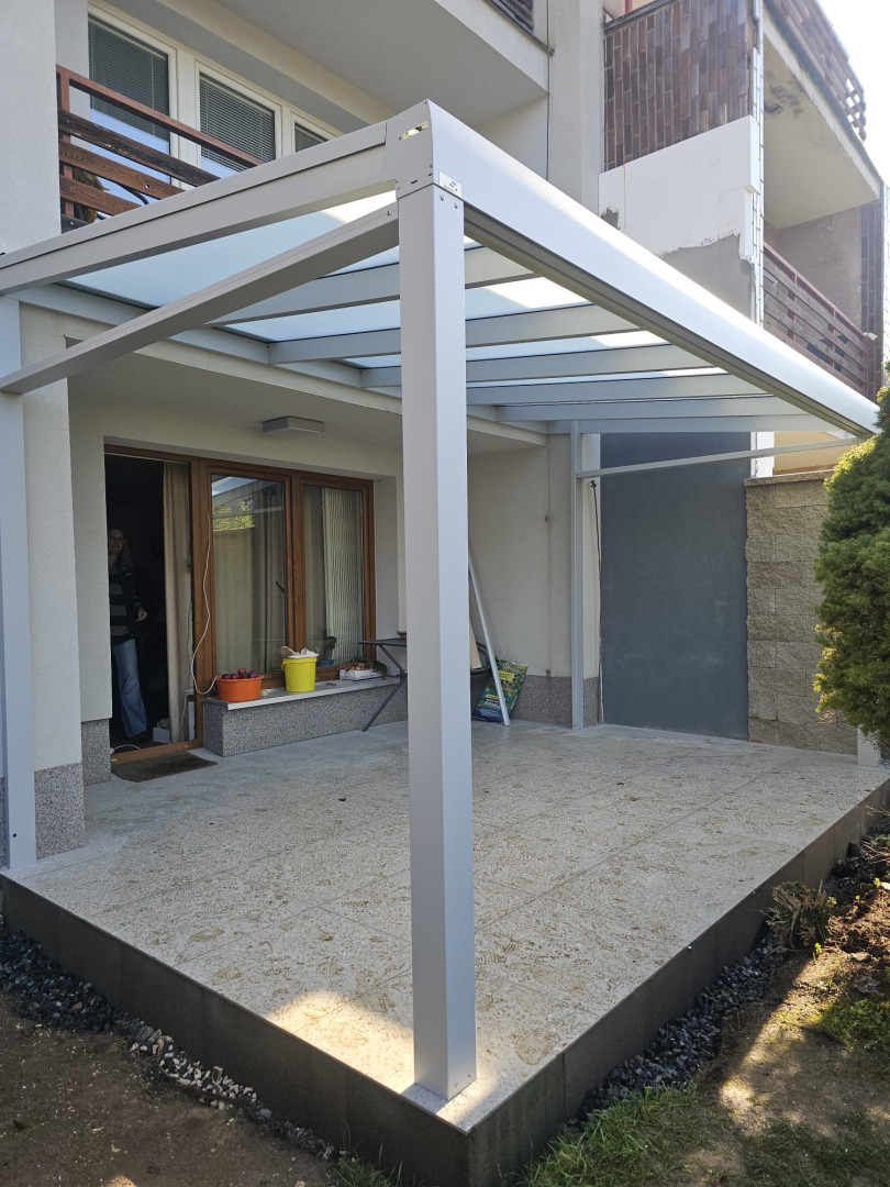 Modern alumínium pergola üvegtetővel egy családi ház teraszán