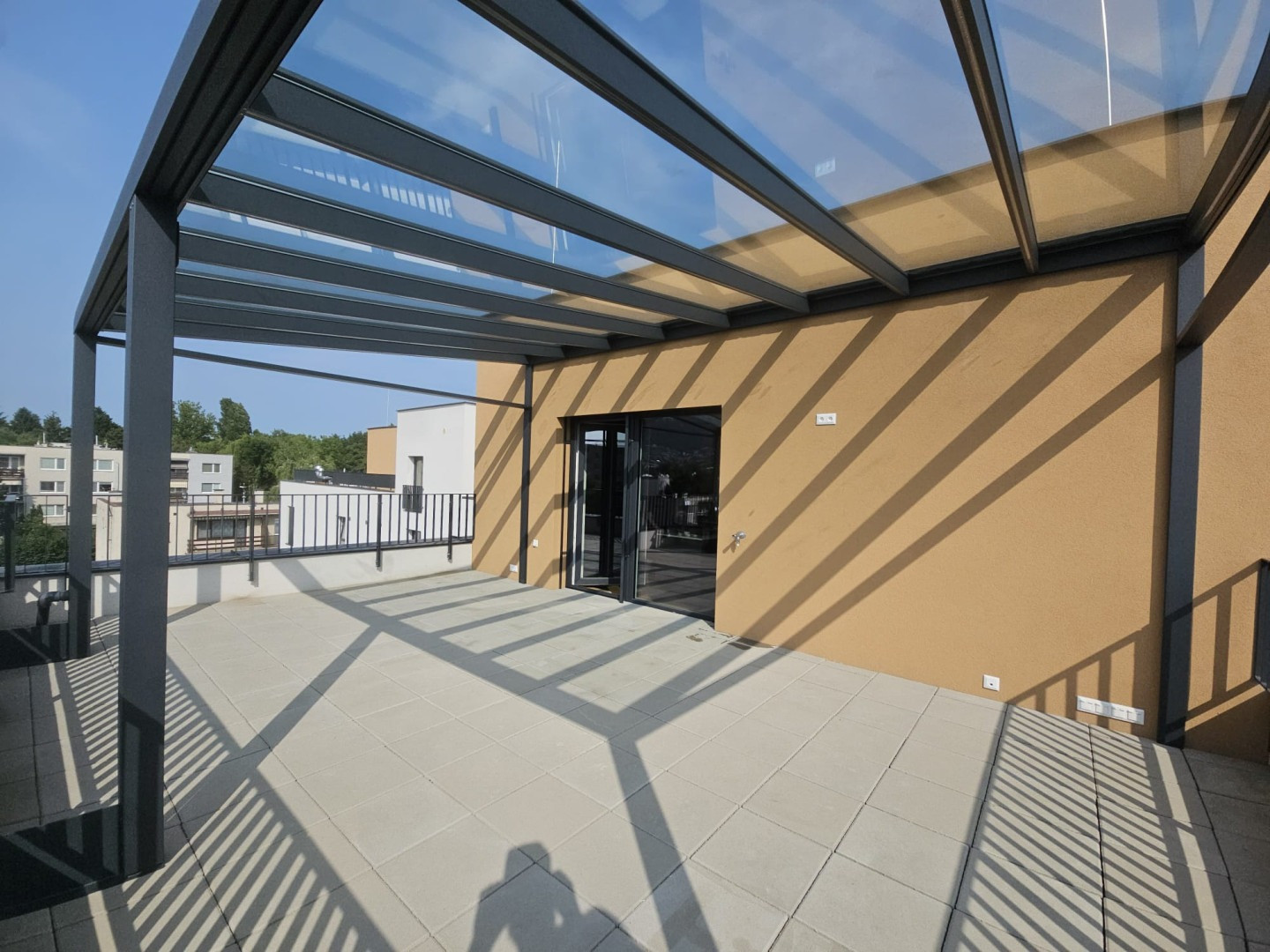 Modern alumínium pergola üvegezett tetővel egy lakóház teraszán