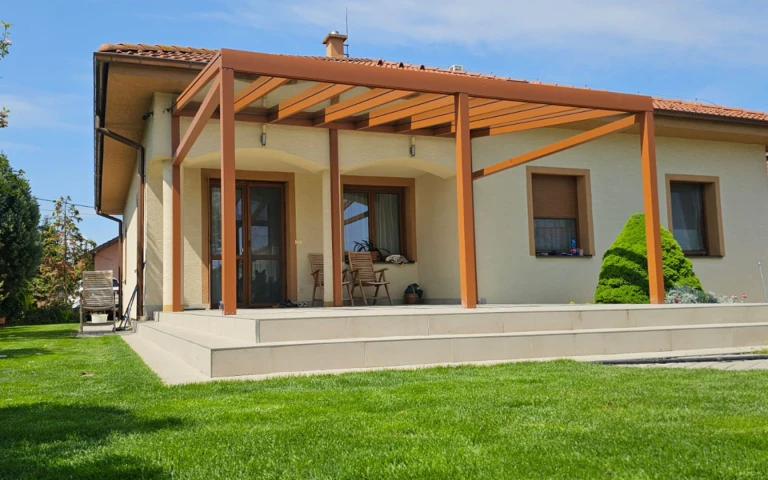 Egy családi ház teraszára felszerelt, fa mintázatú, modern alumínium pergola