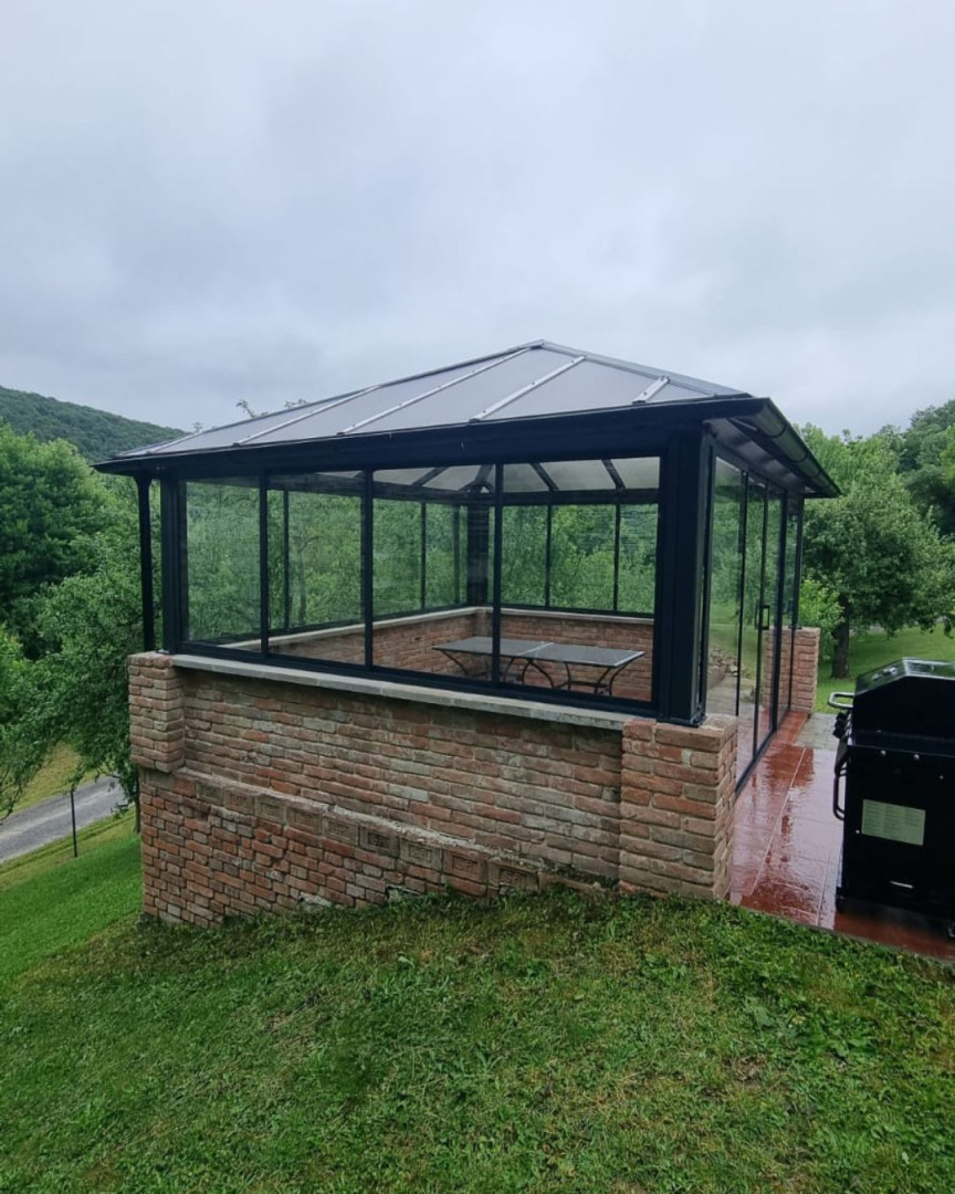 Modern, üvegezett pavilon téglaalapzattal a kertben